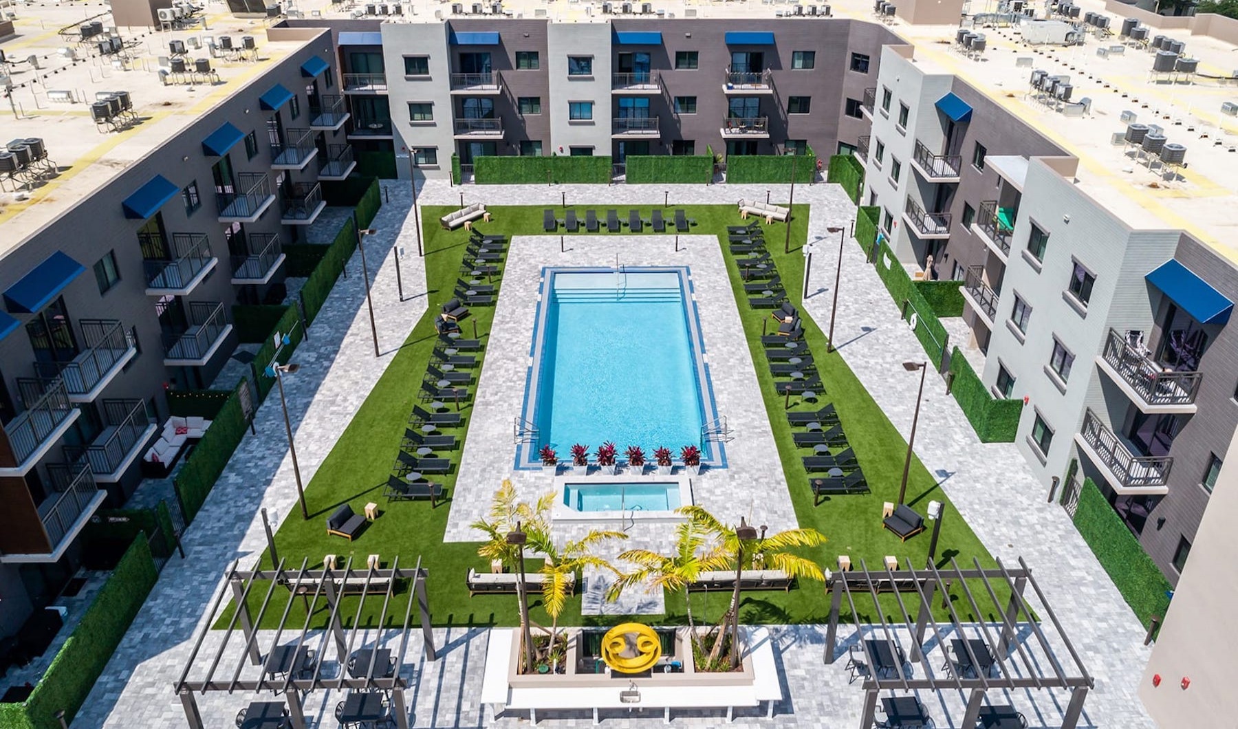 Live Different Aerial view of swimming pool showing spacious seating and easy access to apartment homes